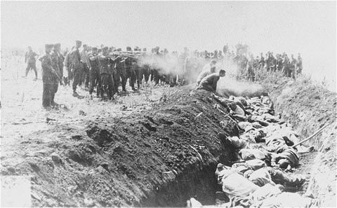 Men with an unidentified unit execute a group of Soviet civilians kneeling by the side of a mass grave